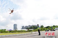 直升机通过救援绳索将救生员和伤者缓缓拉上直升机并送往医院就医